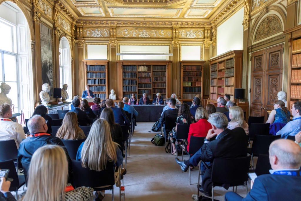 People seated listening to a panel discussion in a ornate library at the UK Global R&D and Science Summit.