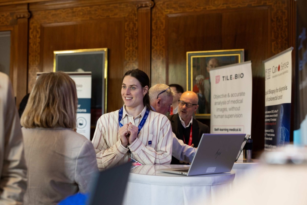 Attendees networking at the UK Global R&D and Science Investment Summit with exhibition banners in the background.