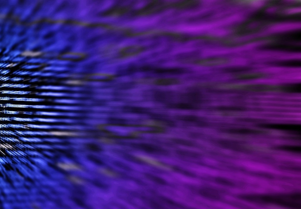 Blurred abstract image of streaking blue-to-purple light with faint code text overlay.