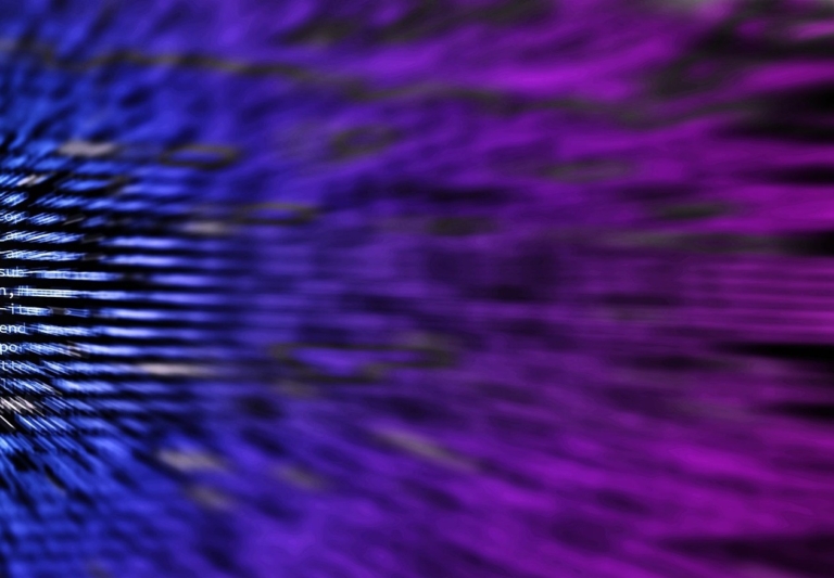 Blurred abstract image of streaking blue-to-purple light with faint code text overlay.